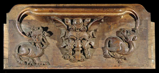 En misericord som viser tre menneskeansikter flankert av monstre, New College Chapel, Oxford, sent på 1300-tallet (tre)
