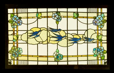 Arts and Crafts-panel av en gruppe svaler foran skyer i en kant av stiliserte blomsterhoder (blyant og glassmalerier)