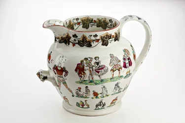 Staffordshire-kanne dekorert med Harlekin-figurer og karneval-tema, 1866 (jernstein Kina)