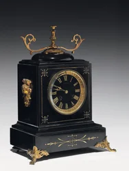 En kappeklokke av svart komposisjonsstein, med innskåret dekor, med ben, slutter og beslag i forgylt messing, av Jausions of Pau, Frankrike, ca. 1876-78 (svart komposisjonsstein, med innsnittede dekorasjoner