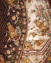 Detalj av en praktfull drakt av brunskåret fløyel, bestående av frakk, knebukser og midje av elfenbensateng brodert med eget bad, ca. 1760