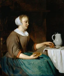 Ung kvinne som spiser ved et bord