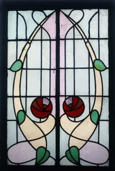 Et farget glasspanel som viser stiliserte roser (blyfarget glass, treramme)
