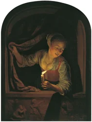 Kvinne med et tent lys ved et vindu