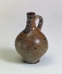 Bartmannkrug eller Bellarmine vinflaske dekorert med en påført skjeggete ansiktsmaske, Tyskland, ca. 1630-40 (saltglasert steintøy)