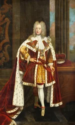 Portrett av kong George II når prinsen av Wales, i full lengde, iført statskapper og krage av strømpebåndsordenen, med sverdet i venstre hånd og kronen på et bord ved siden av ham, i et interiør,