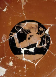 Attic cup with red figures (detail) signed by the potter Kachrylion representing a Greek heros under the guise of a handsome young man wing (May be Eros), 510 BC. Greek ceramic restored. Museo archeologico Firenze. Archaeological Museum of Florence. (detai