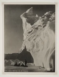 Hundeteam hviler ved et isfjell (bromidtrykk)