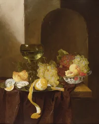 Et stilleben med frukt, en skrelt sitron og en rogn på en avsats