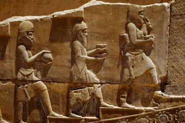Relieffskulptur av menn som bærer offergaver på murene i Persepolis. Persepolis, Iran.