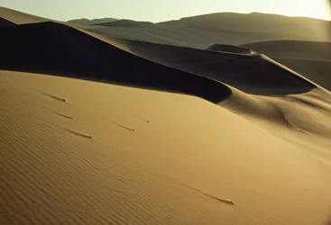 Utsikt over skarpt avtegnede skyggefulle sanddyner nær Dunhuang. Gansu-provinsen, Folkerepublikken Kina.