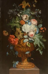 Blomster i en terrakottavase på en sokkel