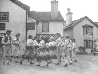 Menn og kvinner som danser på Hawkshead med skilt for #39;15 Century Café#39; bak og auksjonariuser