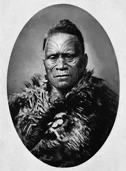 En maorihøvding med forseggjort tatovert ansikt og værkappe, 1902