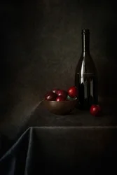 Stilleben med plommer og en flaske