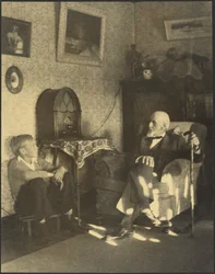 [Mann og gutt sittende i et arbeidsrom]