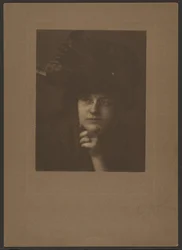 [Portrett av en kvinne med stor hatt og briller]