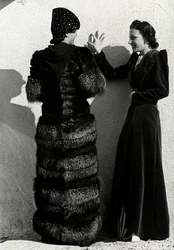 To modeller presenterer kreasjoner av det italienske couture-huset "Dragoni". En modell sett bakfra har på seg en sølvrevefrakk. Den andre modellen har på seg en lang fløyelsfrakk. (s/hvitt bilde)
