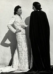 To modeller presenterer kreasjoner av det italienske couture-huset "Dragoni". En modell har på seg et antrekk i bleiemateriale som består av en jakke og et langt skjørt med tog. Den andre modellen, sett bakfra, bærer en lang fløyelsmantel. (s/hvi