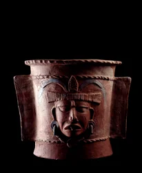 Førkolumbisk kunst, mayasivilisasjonen, senklassisk periode: sylindrisk gravurne av leire dekorert med et menneskeansikt. Fra Quiché, Guatemala. Mål: høyde 38.5 x diameter 39,5 cm. Guatemala, Det nasjonale museet for arkeologi og etnologi