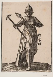 Stående soldat med hjelm, sett forfra; i r. hånd en krigshammer, i v. hånd en krigskølle, bakbein og fot forvrengt i forhold til fronten; ved v. side et sverd