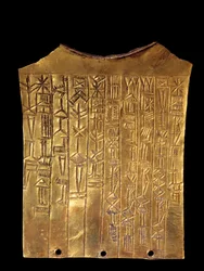 Mesopotamia: gullvotivplate i form av et skjegg dedikert til guden Sara. Den er dekket med kileskrift. Fra Ummah. 2370 f.Kr. Paris, Louvre-museet