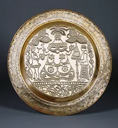 En Efik messinglader preget med en sentral kledd kvinnefigur og to tjenere som holder en vifte og en paraply