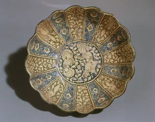 Hvit keramikkbolle med underglasurmaling i svart og blått med mongolske figurer