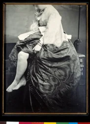 Grevinnne Verasis de Castiglione, født Virginia Oldoini, sittende på et bord. Grevinnen løfter kjolen for å blottlegge ben og føtter. Sølvgelatinbromidprøve, 1863, Paris, Musée d