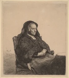 Kunstnerens mor sitter ved et bord og ser mot høyre