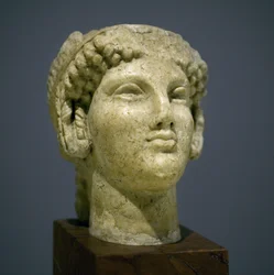 Jentehode (Kore), skulptur fra den romerske hellenistiske perioden (3. 2. århundre etter vår tidsregning), veldig uttrykksfulle ansikt, fremtredende kinnbein mot øst, smil, krøllete hår, arkaisk stil til Ionie på 600-tallet før vår tidsregning som fortsatt