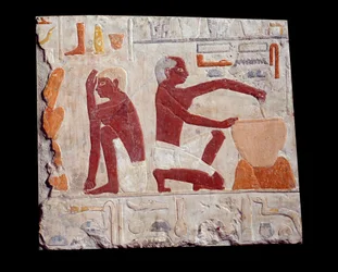 Gammel egyptisk kunst: brødbaking. En mann lager kakedeig, en annen overvåker bakingen av brødformer. Kalkstein (2500-2350 f.Kr.), 5. dynasti. Paris, Musée du Louvre