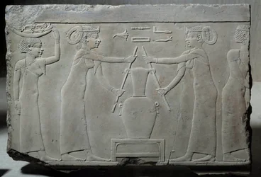 Egyptisk antikvitet: lavt kalksteinsrelieff som representerer kvinner som presser liljeblomster for å trekke ut essensen kalt "lirinon-ekstraksjon" rundt 500-400 f.Kr. (Saite-tiden?). Lav epoke. Søn 0,29x0,37 m Paris, musee du Louvre