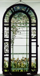 Et spaltevindu av blyglass som viser klematisranker, tidlig på 1900-tallet (blyglass)