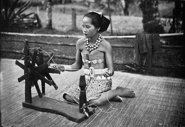 En Dayak-jente ved sitt spinnehjul, 1902