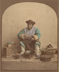 [Kinesisk mann sitter med verktøy], 1870-tallet.