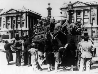 Franske gateselgere tilbyr suvenirer til en lastebil med tyske soldater, Paris, 27. juli 1940