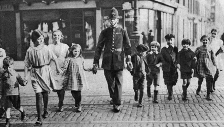 Politimann som hjelper skolebarn over veien, East End, London, 1926-1927