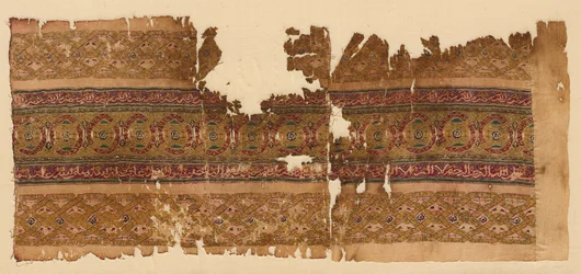 Tiraz med guillosjebånd, 1100-tallet.