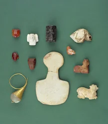Samling av gjenstander fra det østlige middelhavsområdet, inkludert en sumerisk gribbamulett, en akkadisk serpentinsel og en mesopotamisk karneolfrosk, fra 3300 til 2000 f.Kr.
