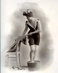 Ung kvinne i badedrakt (fra Belle Epoque) som tar et fotbad, rundt 1900 (s/hvitt-bilde)
