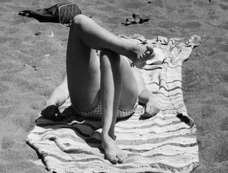 Feminine ben på en strand, ca. 1960 (s/h-foto)