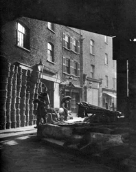 Fruktkurver stablet mot hus på Borough Market, London, 1926-1927.