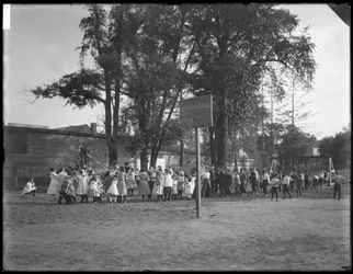 Gutter og jenter leker dragkamp på en uidentifisert lekeplass, ca. 1910