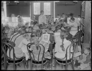 Barn som leser på lesesalen til en uidentifisert filial av Queens Borough Public Library, ca. 1910.