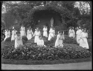 Avgangsklasse med jenter fra det romersk-katolske foreldreløse asylet i blomsterhagen, foran Jomfru Marias grotte, 1912 bw foto