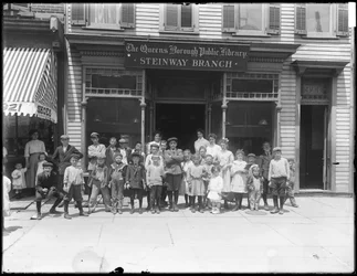Gruppeportrett av barn foran Steinway-grenen til Queens Borough Public Library, ca. 1910